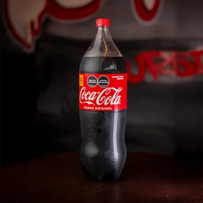 Botella de gaseosa Mega disponible en sabores Coca Cola, Kola y Manzana en El Torete Burger Girón Santander.